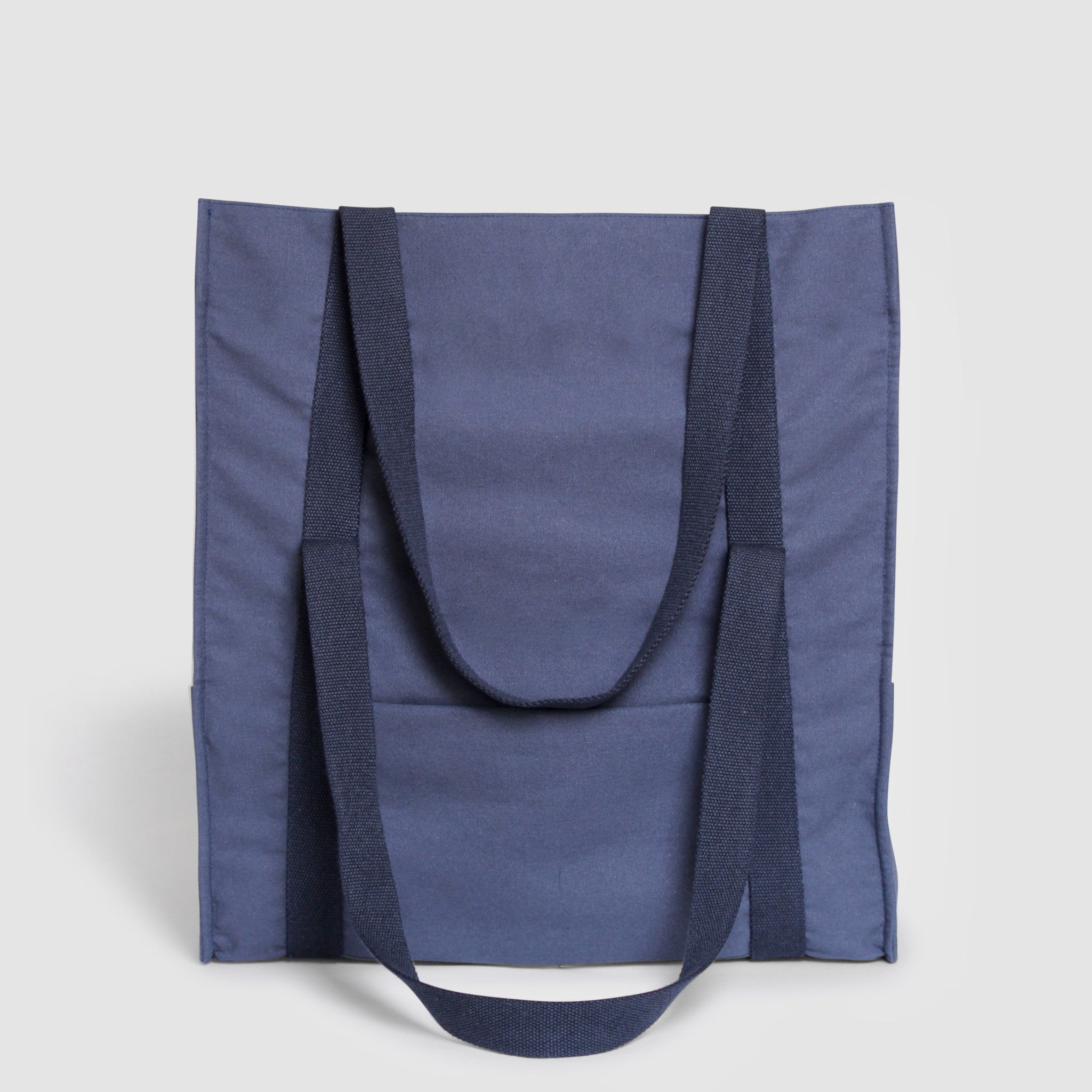 Blue canvas travel bag with matching blue straps, expandable height, zippered exterior pocket, trolley sleeve, and organized interior compartments for mobile phone and wallet, perfect as a weekender or baby bag