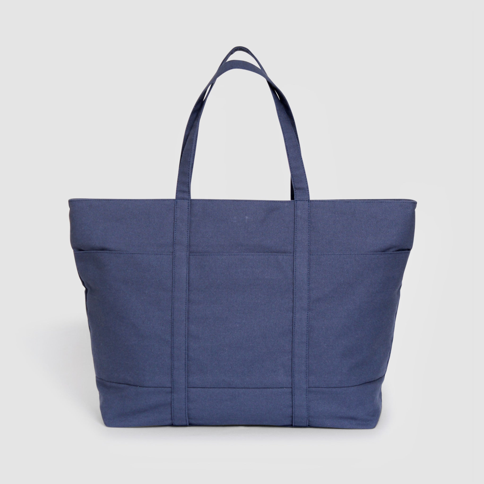 Blue structured cotton canvas tote bag with organic cotton lining, front pockets, removable shoulder strap, and magnetic closure, 50×14×32 cm