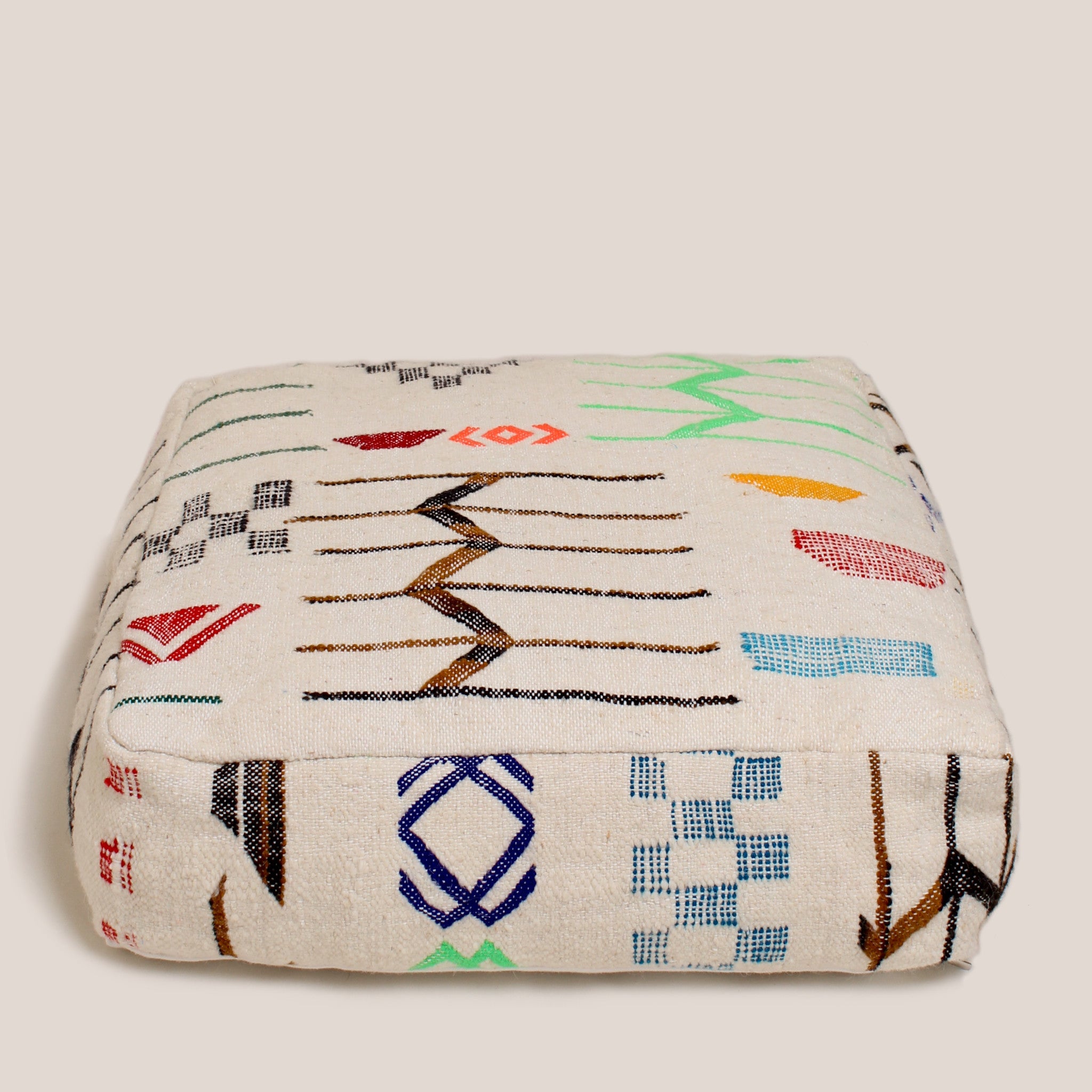 Beige Moroccan wool pouf with colorful handwoven Berber motifs, 60×60×20 cm, handmade and ethically finished in Portugal