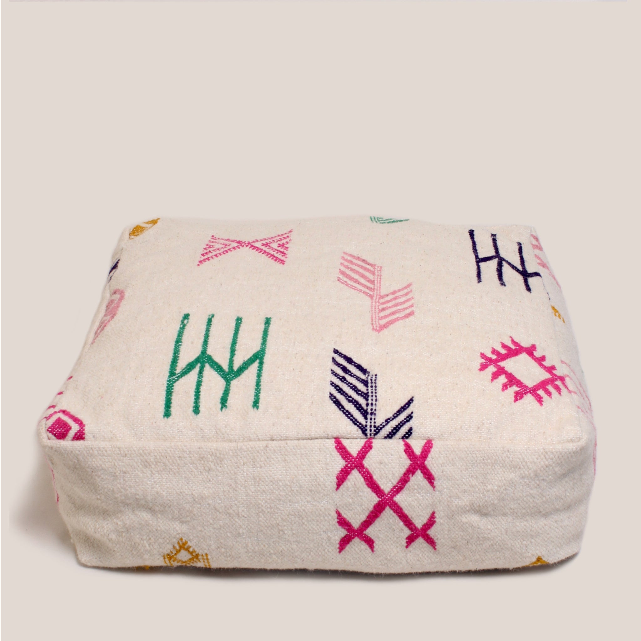 Handmade Moroccan pouf in beige with colorful Berber motifs, crafted from Azilal rug in the Atlas Mountains, 60×60×20 cm wool floor cushion